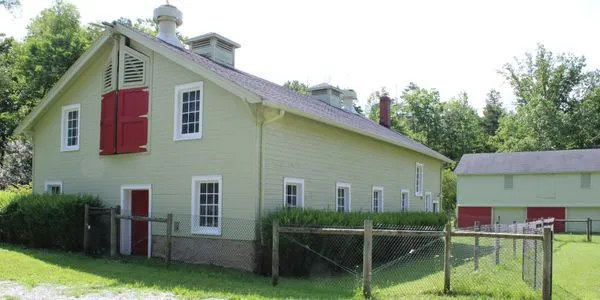 A view across the sanctuary&rsquo;s open grounds and weathered farm buildings.